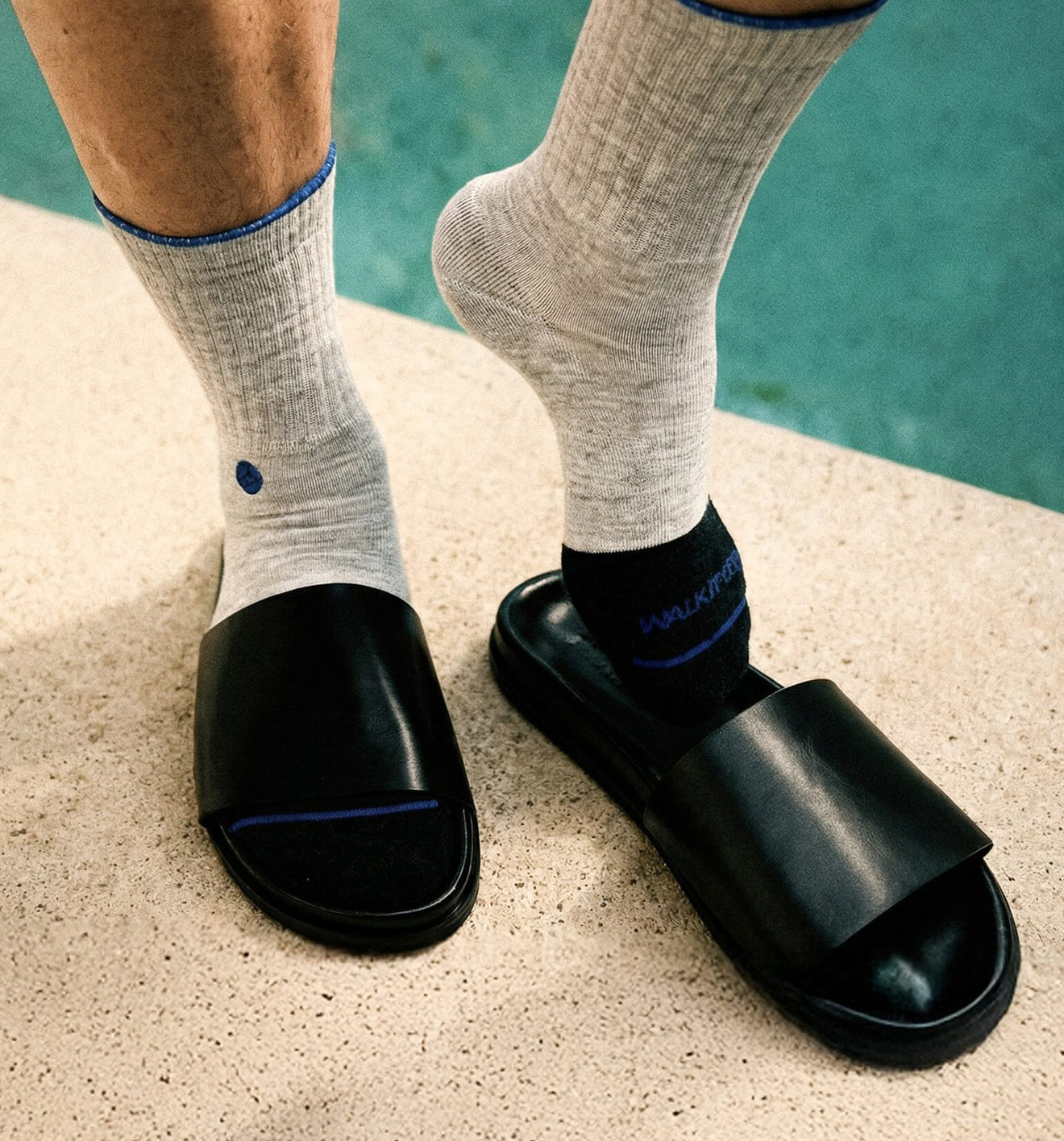 Grey merino wool socks by WALK IT OFF (The 24/7 Platino) worn with black slides by the pool.