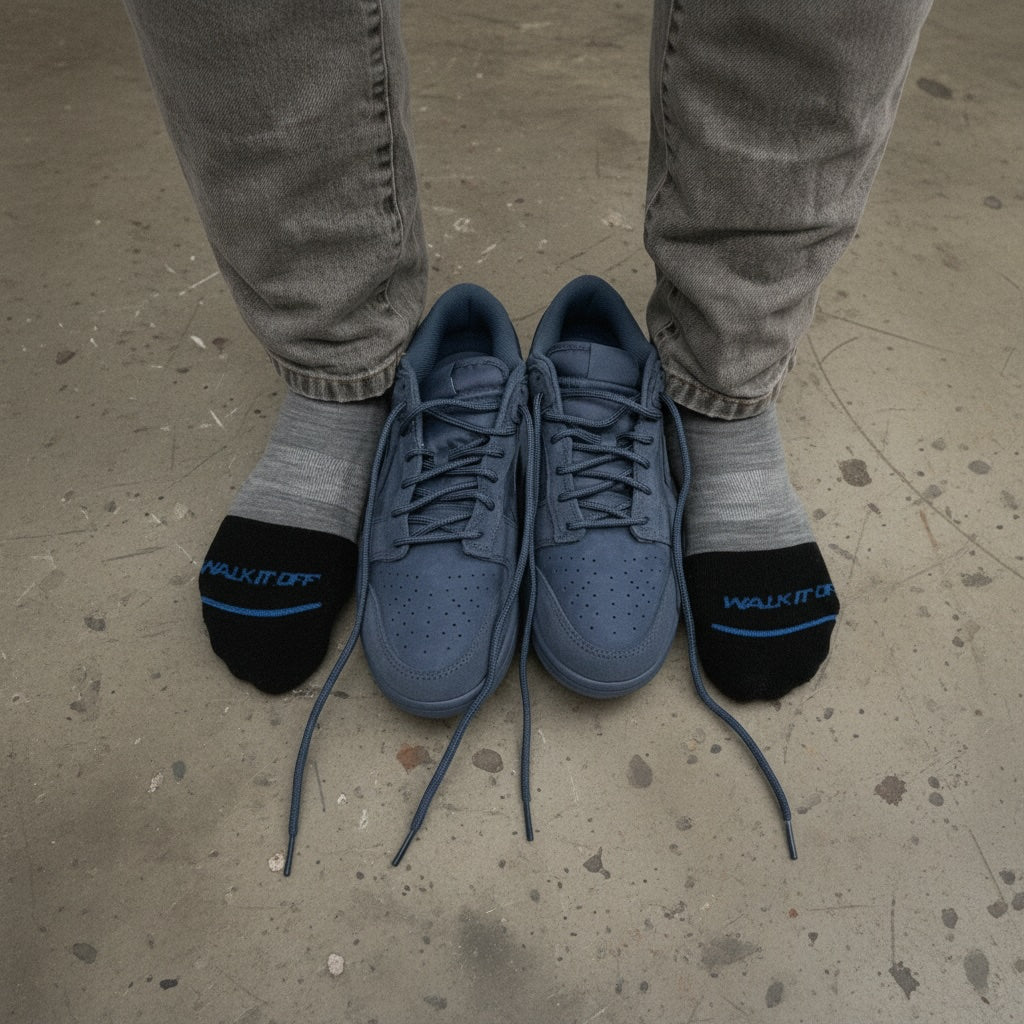 Grey WALK IT OFF merino wool socks worn next to blue sneakers.