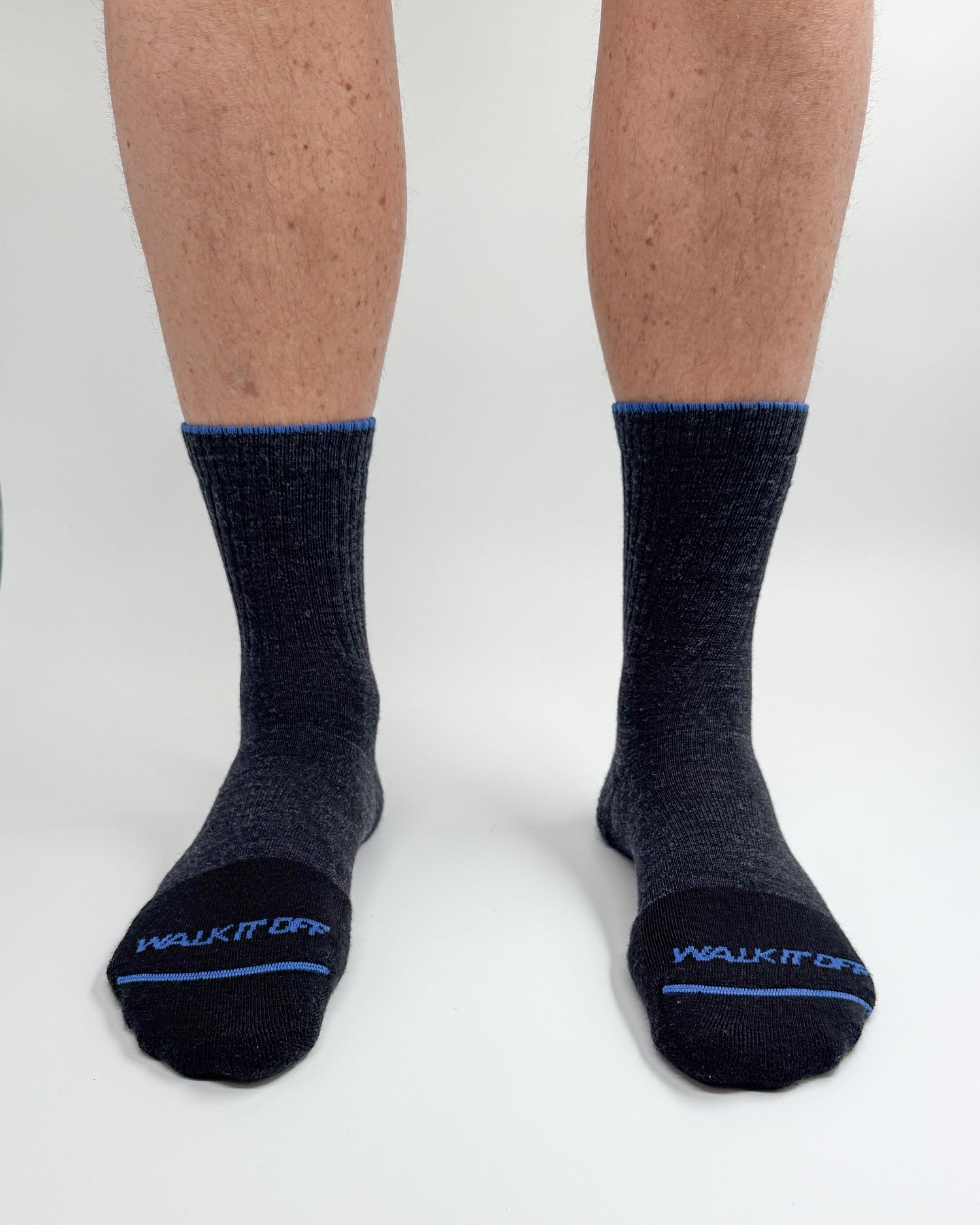 Model draagt de WALK IT OFF merino sokken in de kleur Grigio Antracite, gefotografeerd recht van voren op een witte achtergrond.