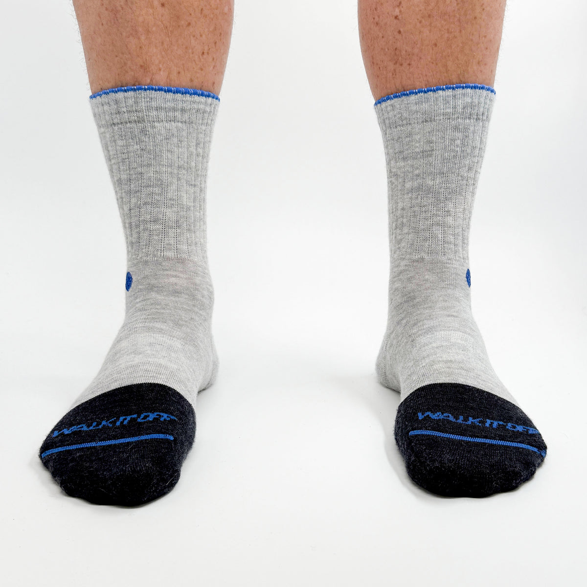 Model draagt de WALK IT OFF merino sokken in de kleur Platino, gefotografeerd recht van voren op een witte achtergrond.