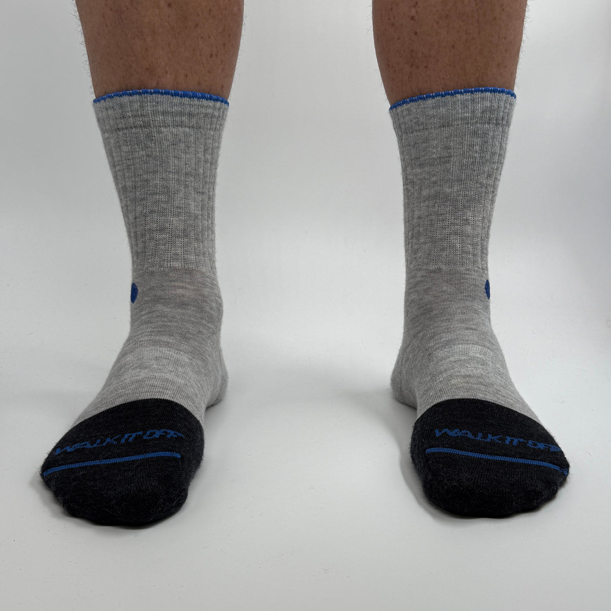 Model draagt de WALK IT OFF merino sokken in de kleur Platino, gefotografeerd recht van voren op een witte achtergrond.