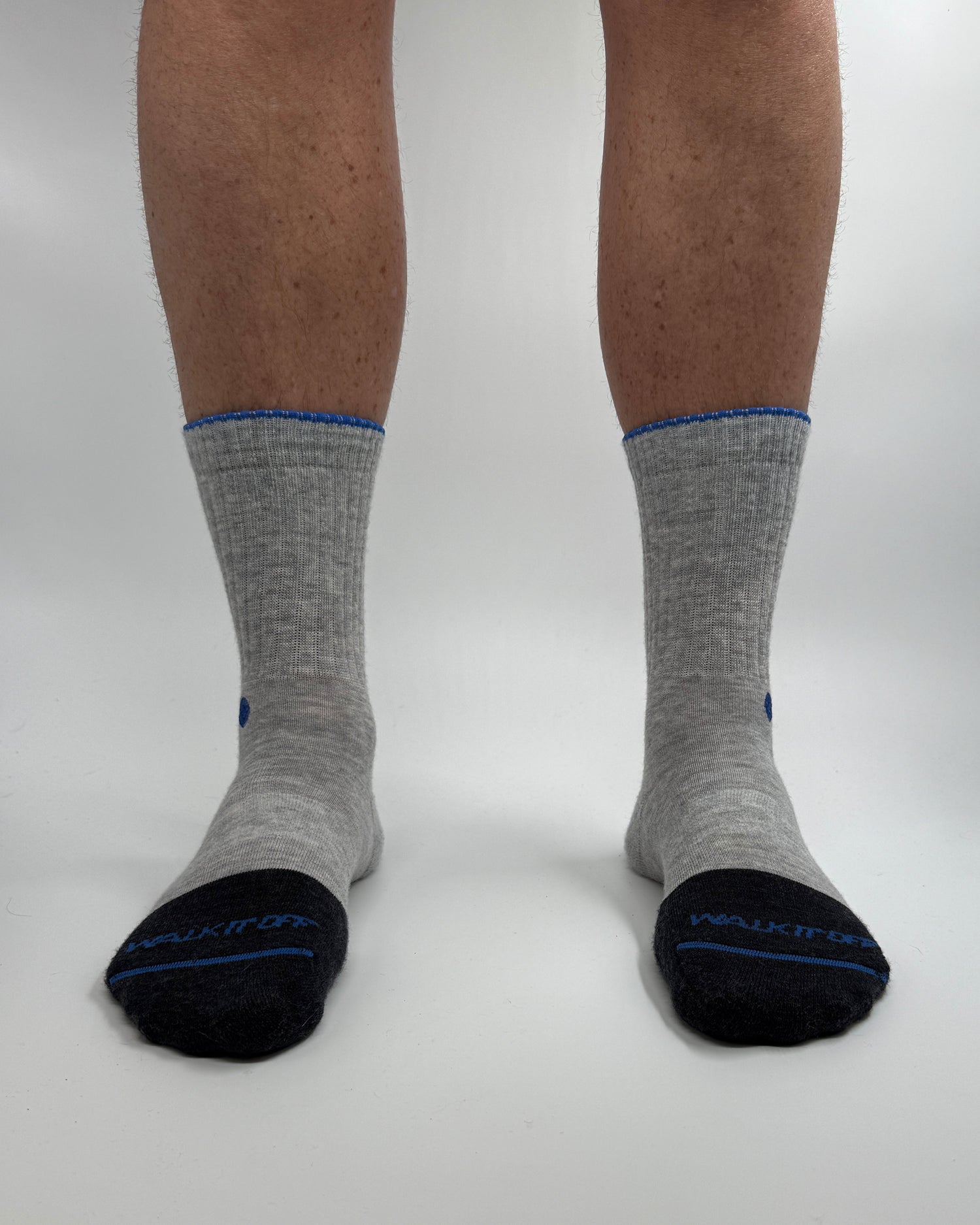 Model draagt de WALK IT OFF merino sokken in de kleur Platino, gefotografeerd recht van voren op een witte achtergrond.