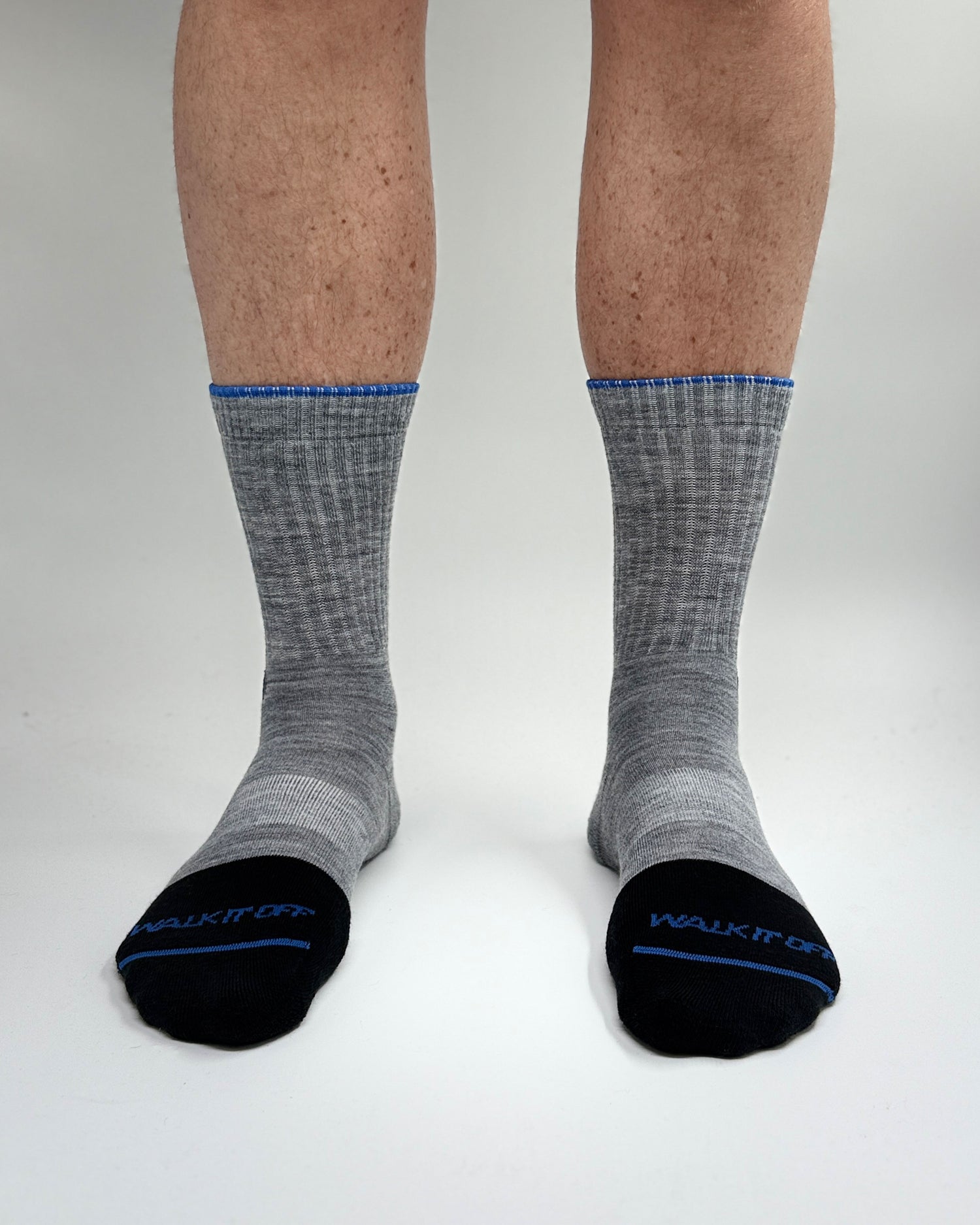 Model draagt de WALK IT OFF merino sokken in de kleur Twister, gefotografeerd recht van voren op een witte achtergrond.