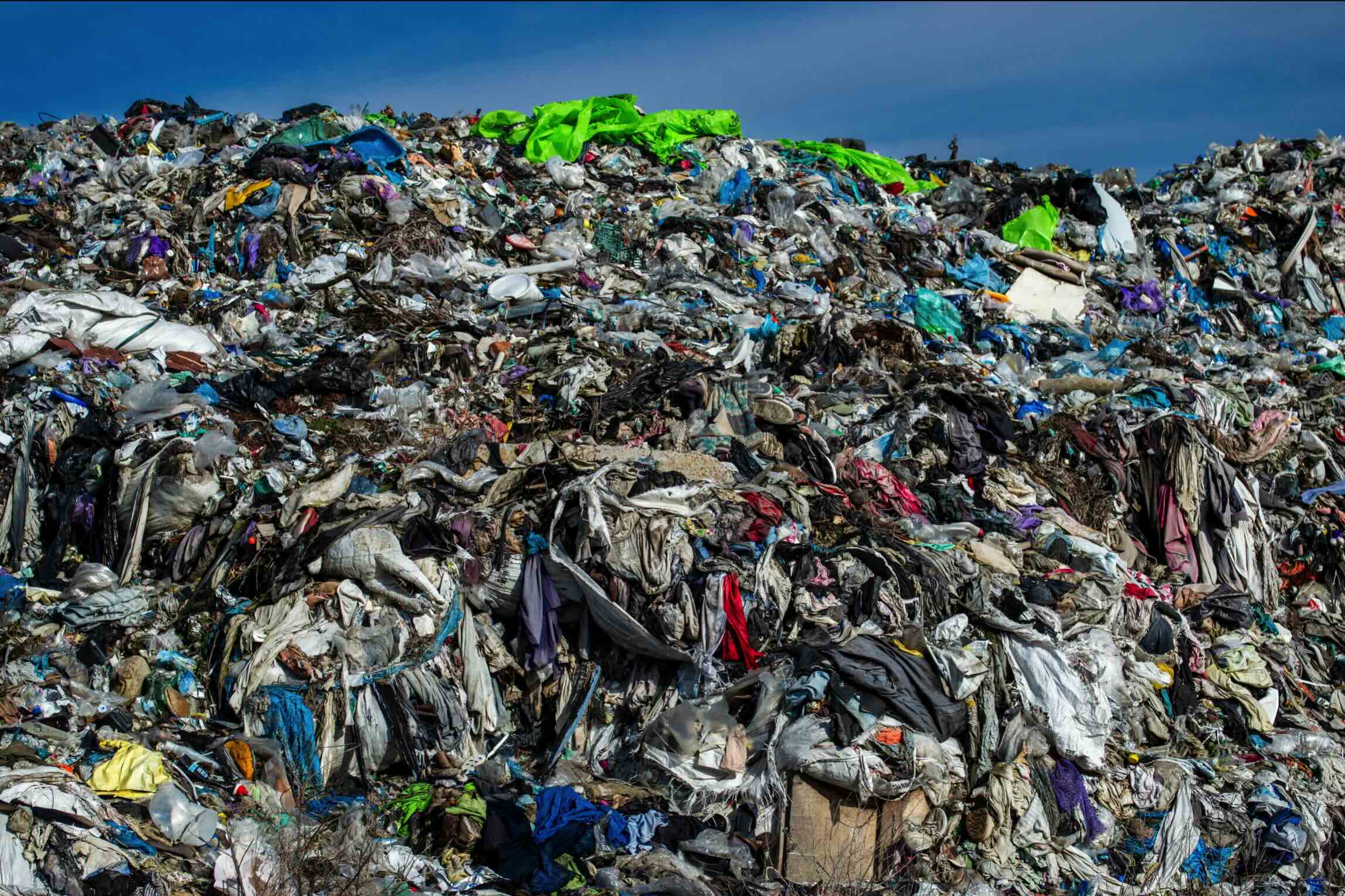 Grote berg textielafval die laat zien waarom duurzaamheid van sokken en kleding belangrijk is.
